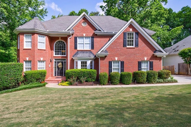 view of front facade with brick siding and roof with shingles