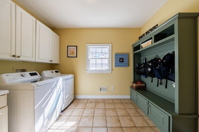 laundry area featuring cabinet space, independent washer and dryer, baseboards, and light tile patterned floors