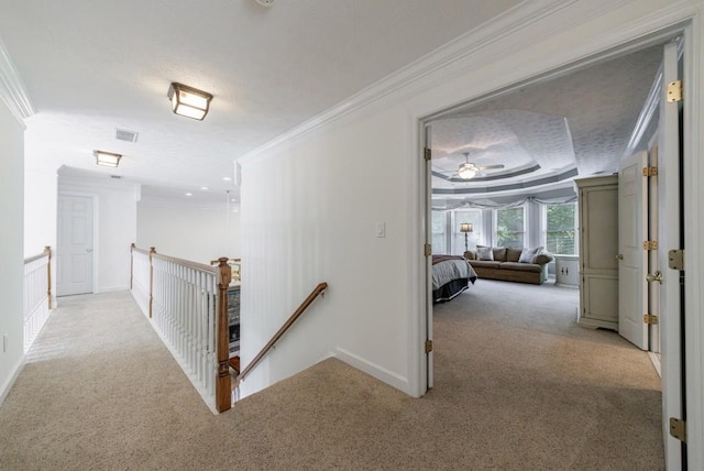 corridor featuring carpet flooring, ornamental molding, an upstairs landing, and baseboards