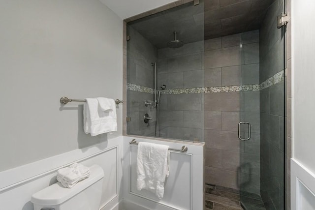 bathroom featuring a shower stall and toilet