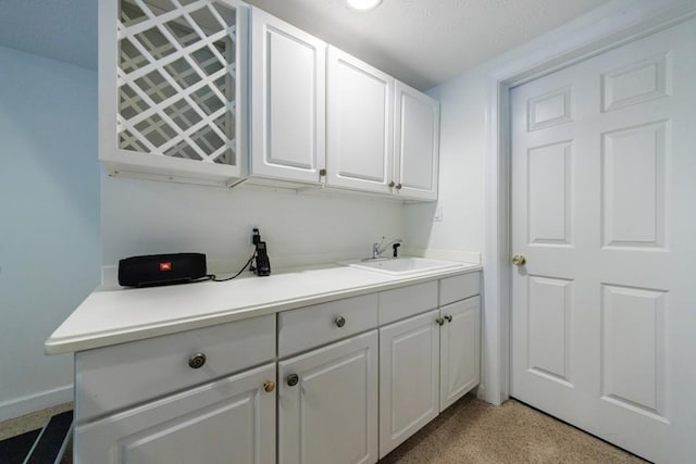 clothes washing area featuring a sink and baseboards