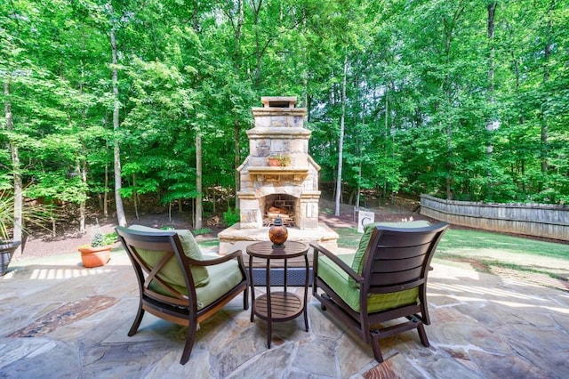 view of patio / terrace with an outdoor stone fireplace and fence