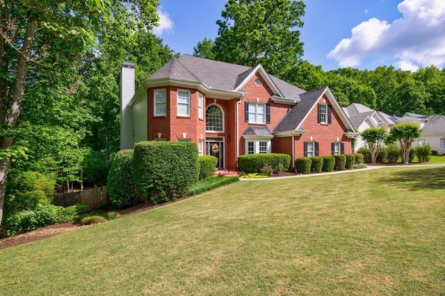 view of front of home featuring brick siding and a chimney
