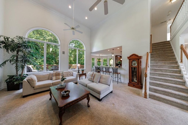 living room featuring high vaulted ceiling, a ceiling fan, crown molding, carpet, and baseboards