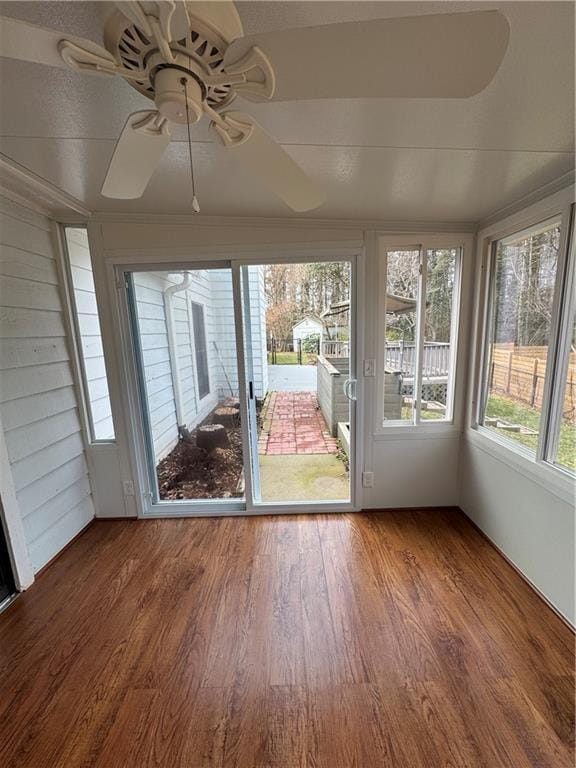 unfurnished sunroom featuring ceiling fan