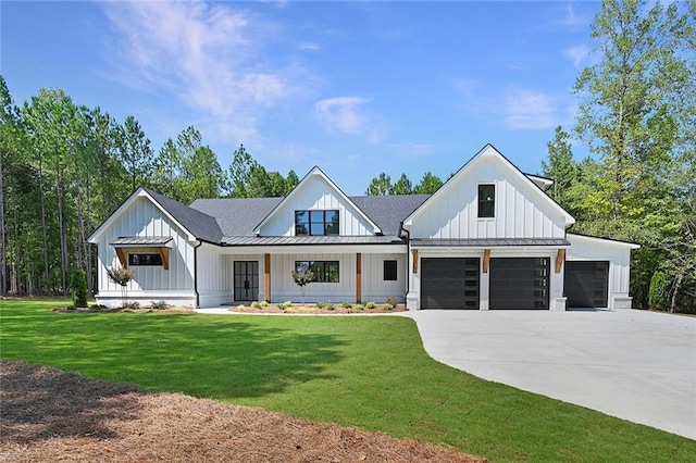 modern farmhouse featuring a front yard, a garage, and a porch