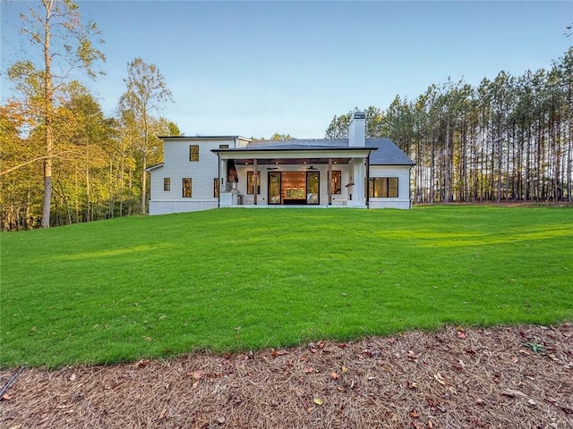 rear view of house featuring a yard and a patio