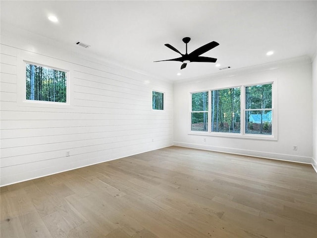 unfurnished room with ceiling fan, hardwood / wood-style floors, ornamental molding, and a healthy amount of sunlight