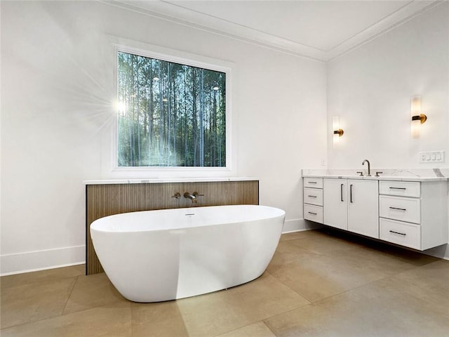 bathroom with a bathtub, ornamental molding, and vanity