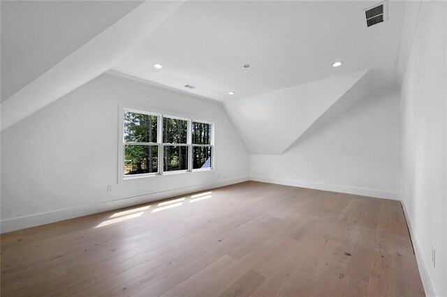 bonus room featuring lofted ceiling and light hardwood / wood-style flooring