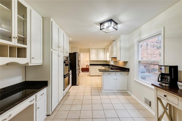 kitchen featuring light tile patterned floors, visible vents, white cabinetry, a sink, and recessed lighting