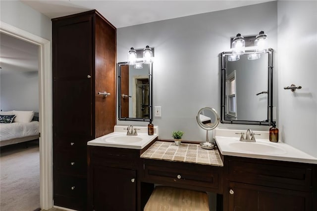 bathroom with ensuite bathroom, double vanity, and a sink