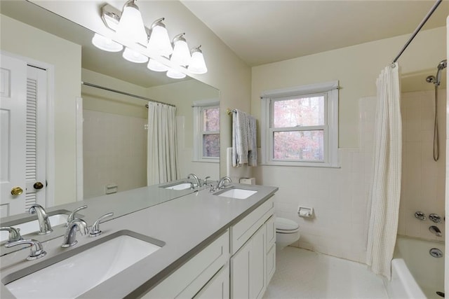 bathroom with a sink, tile walls, and toilet