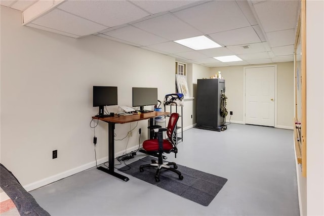 office space with a paneled ceiling, finished concrete flooring, and baseboards