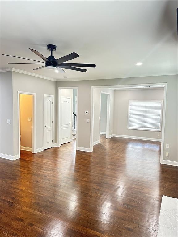540 Langley Creek Dr, Loganville, GA 30052 - empty room with ceiling fan, ornamental molding, dark wood-style floors, recessed lighting, and stairway