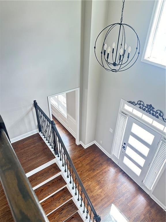 540 Langley Creek Dr, Loganville, GA 30052 - stairway featuring a chandelier, wood finished floors, and a high ceiling