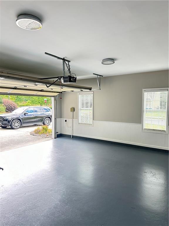 540 Langley Creek Dr, Loganville, GA 30052 - garage with wainscoting and a garage door opener