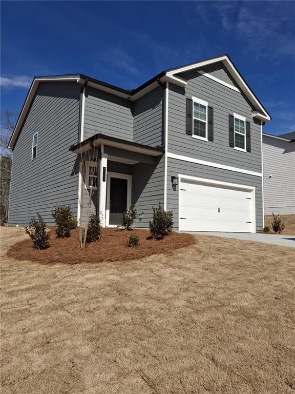 view of front of house featuring a front lawn and a garage