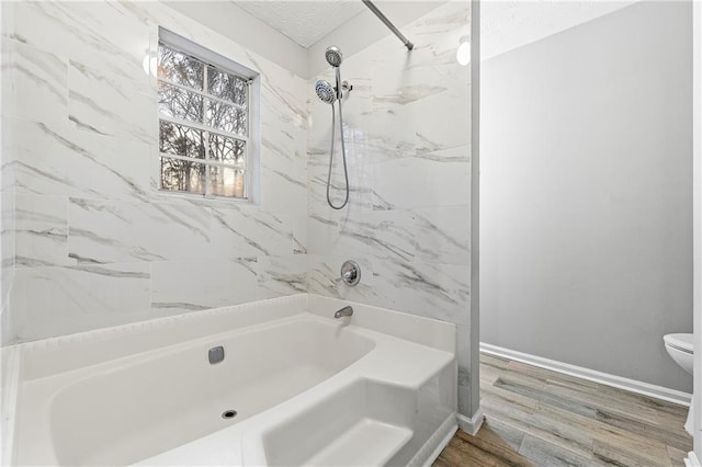 full bath featuring shower / bathtub combination, toilet, baseboards, and wood finished floors