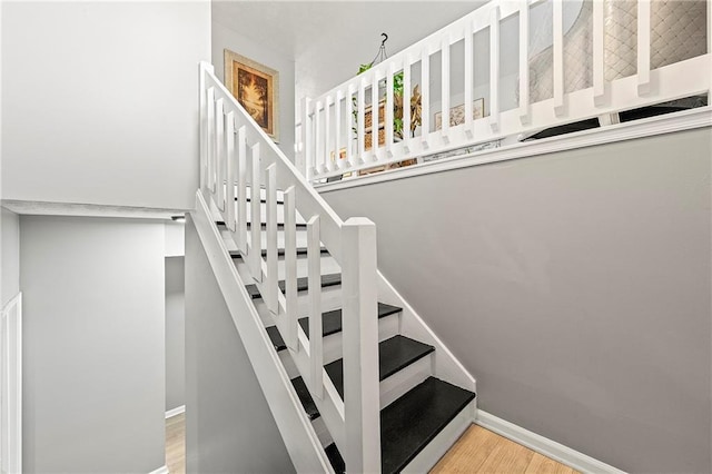 stairs with baseboards and wood finished floors