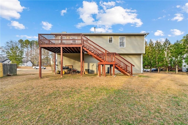 rear view of house with a deck, a lawn, and stairway