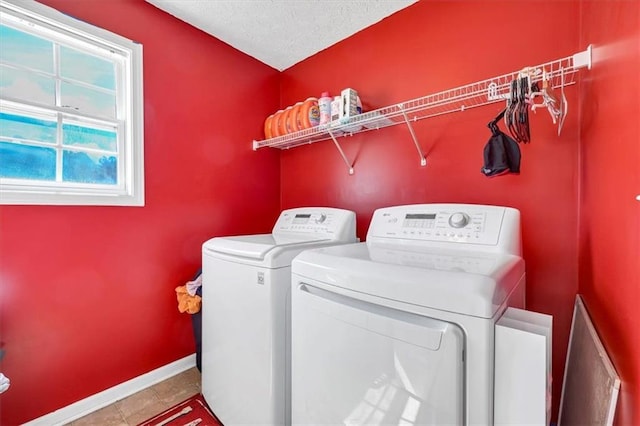 washroom with a textured ceiling, washer and clothes dryer, and tile patterned floors