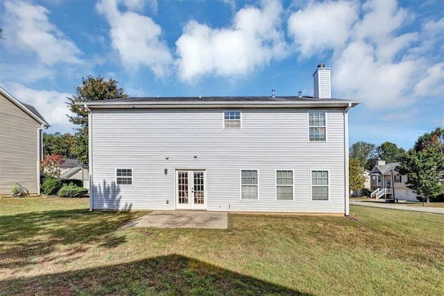 rear view of property featuring a patio area, a yard, and french doors