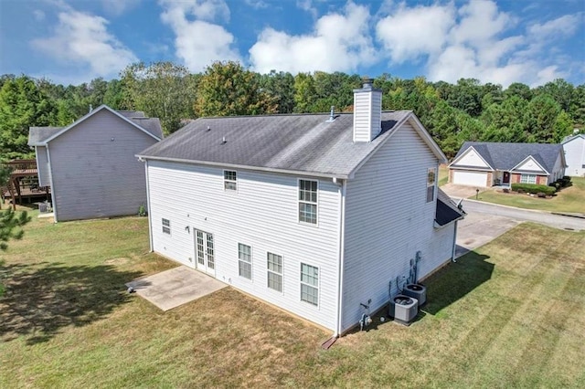 back of property with a lawn and french doors