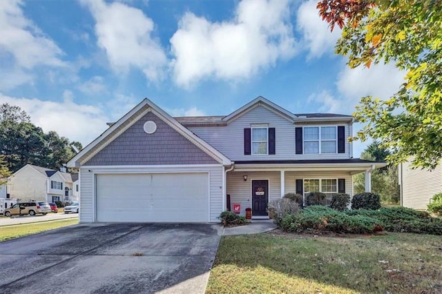 view of front of home featuring covered porch, a front yard, and a garage