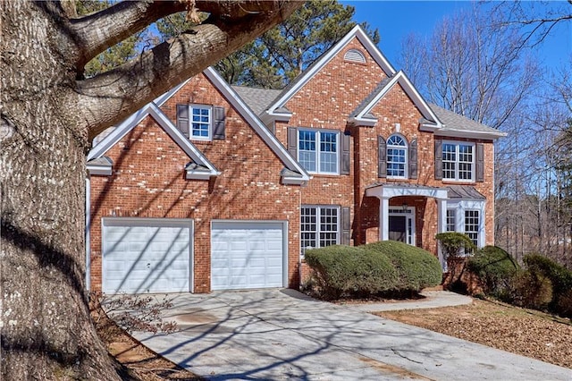 colonial-style house with concrete driveway, brick siding, a chimney, and an attached garage