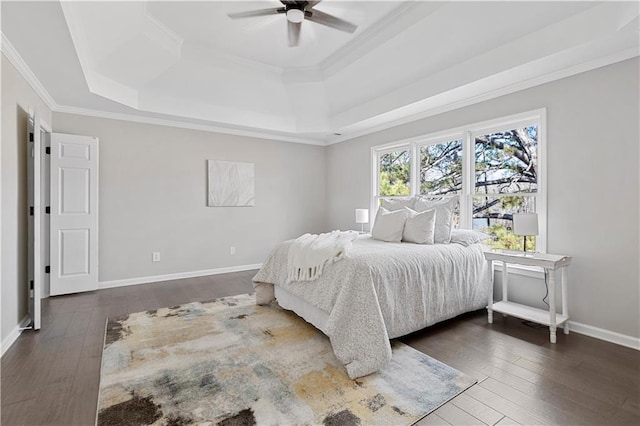 bedroom featuring hardwood / wood-style flooring, a raised ceiling, and crown molding