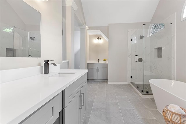 bathroom with a freestanding tub, vaulted ceiling, vanity, and a marble finish shower