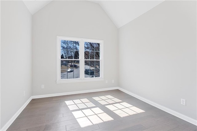 unfurnished room with vaulted ceiling, wood finished floors, and baseboards