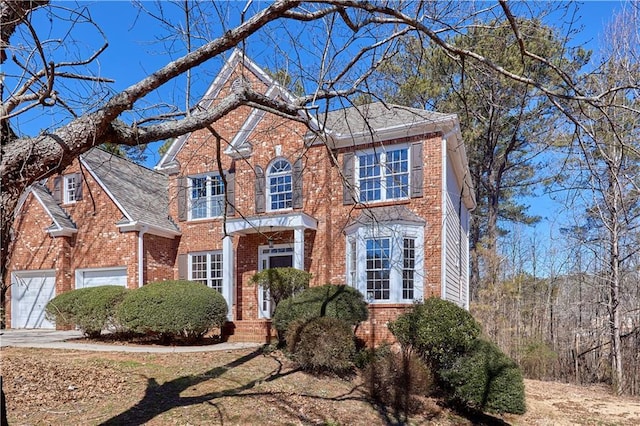 view of front facade with a garage, concrete driveway, and brick siding