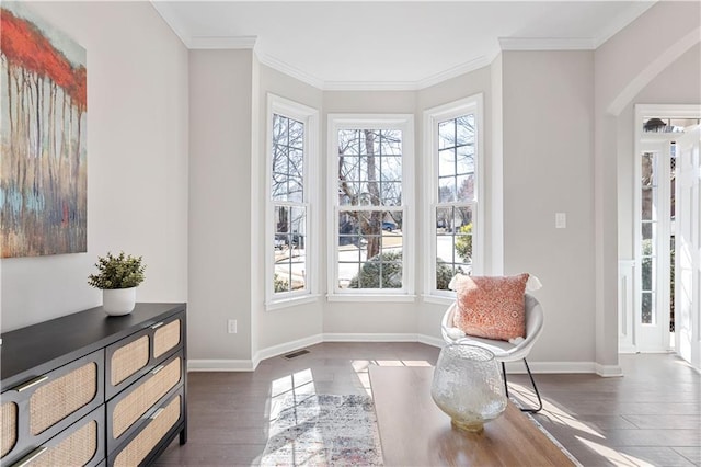 living area with crown molding, visible vents, dark wood finished floors, and baseboards