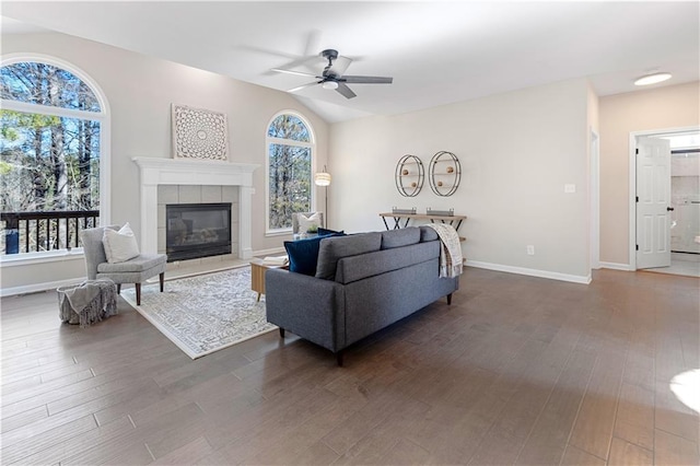 living area with dark wood-style floors, ceiling fan, lofted ceiling, and a healthy amount of sunlight