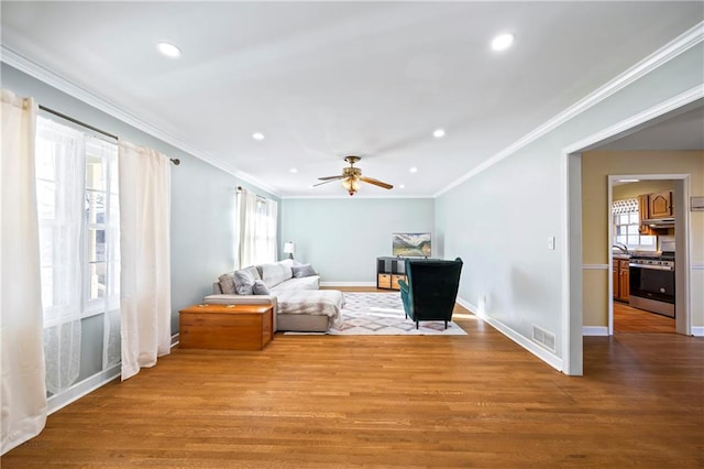 interior space featuring plenty of natural light, crown molding, visible vents, and wood finished floors