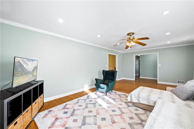 interior space featuring baseboards, wood finished floors, visible vents, and crown molding