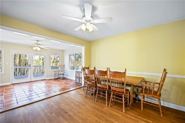 dining area with french doors, ceiling fan, baseboards, and wood finished floors