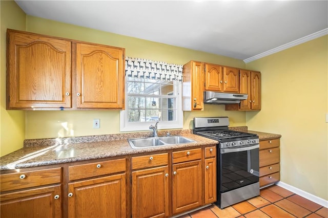 kitchen with light tile patterned floors, under cabinet range hood, a sink, stainless steel gas stove, and brown cabinetry