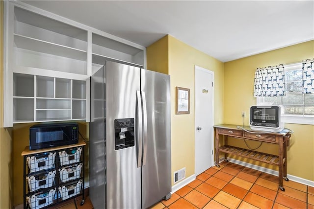 kitchen with stainless steel fridge, baseboards, visible vents, tile patterned flooring, and black microwave