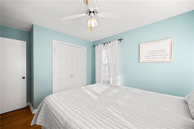 bedroom featuring ceiling fan, baseboards, a closet, and wood finished floors