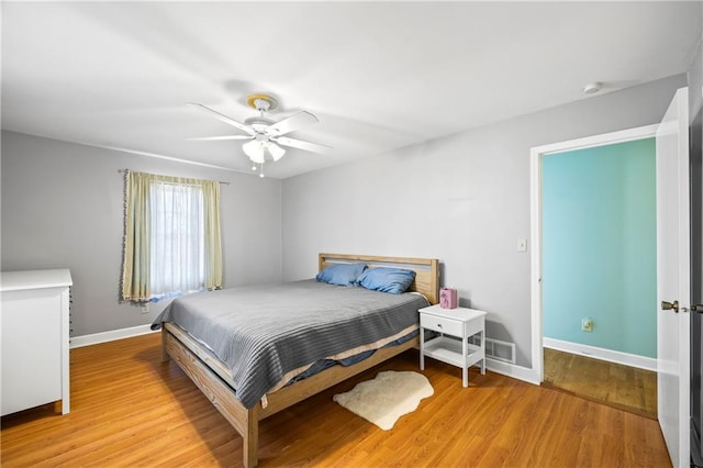 bedroom featuring a ceiling fan, light wood-style flooring, and baseboards