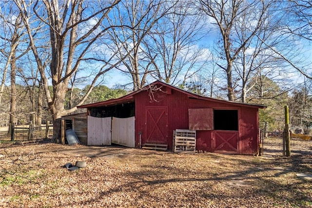 view of barn featuring fence