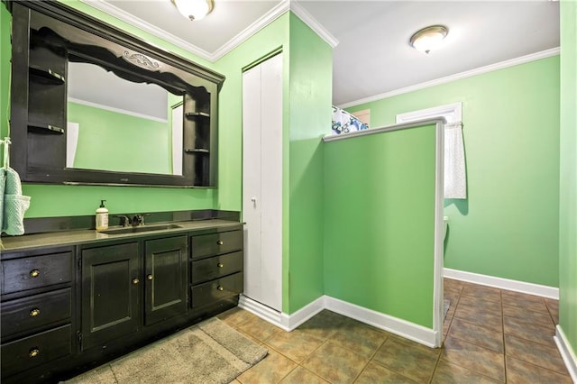 bathroom featuring tile patterned flooring, baseboards, crown molding, and vanity