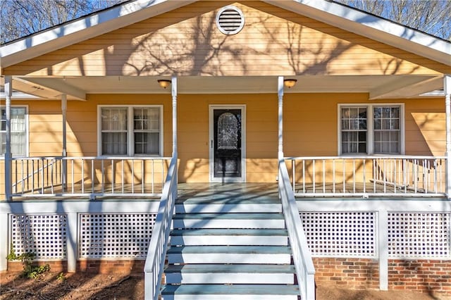 view of exterior entry with covered porch