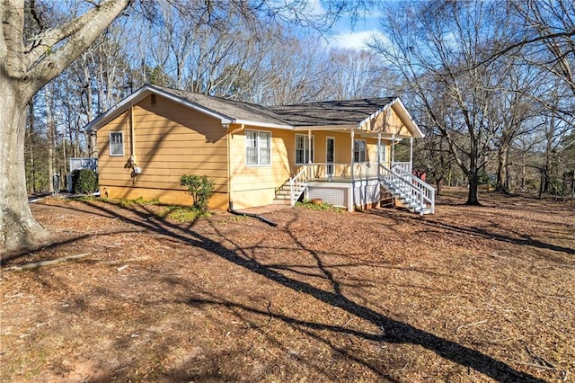 view of front of home featuring covered porch and stairway