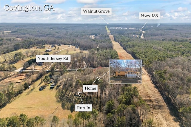 birds eye view of property with a rural view and a wooded view