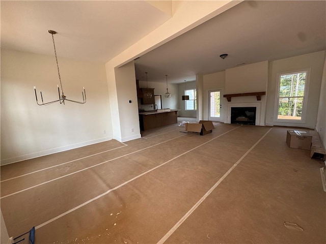 1010 Cable Rd, Waleska, GA 30183 - unfurnished living room featuring concrete floors, baseboards, a chandelier, and a fireplace