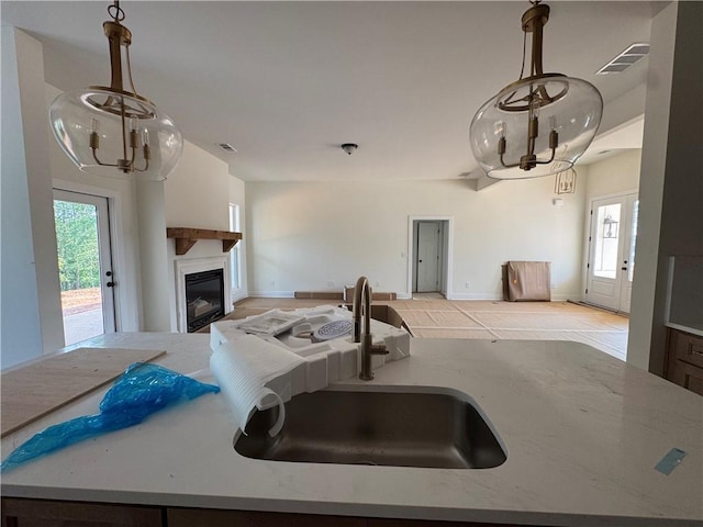 1010 Cable Rd, Waleska, GA 30183 - kitchen featuring a chandelier, a sink, a glass covered fireplace, light stone counters, and open floor plan